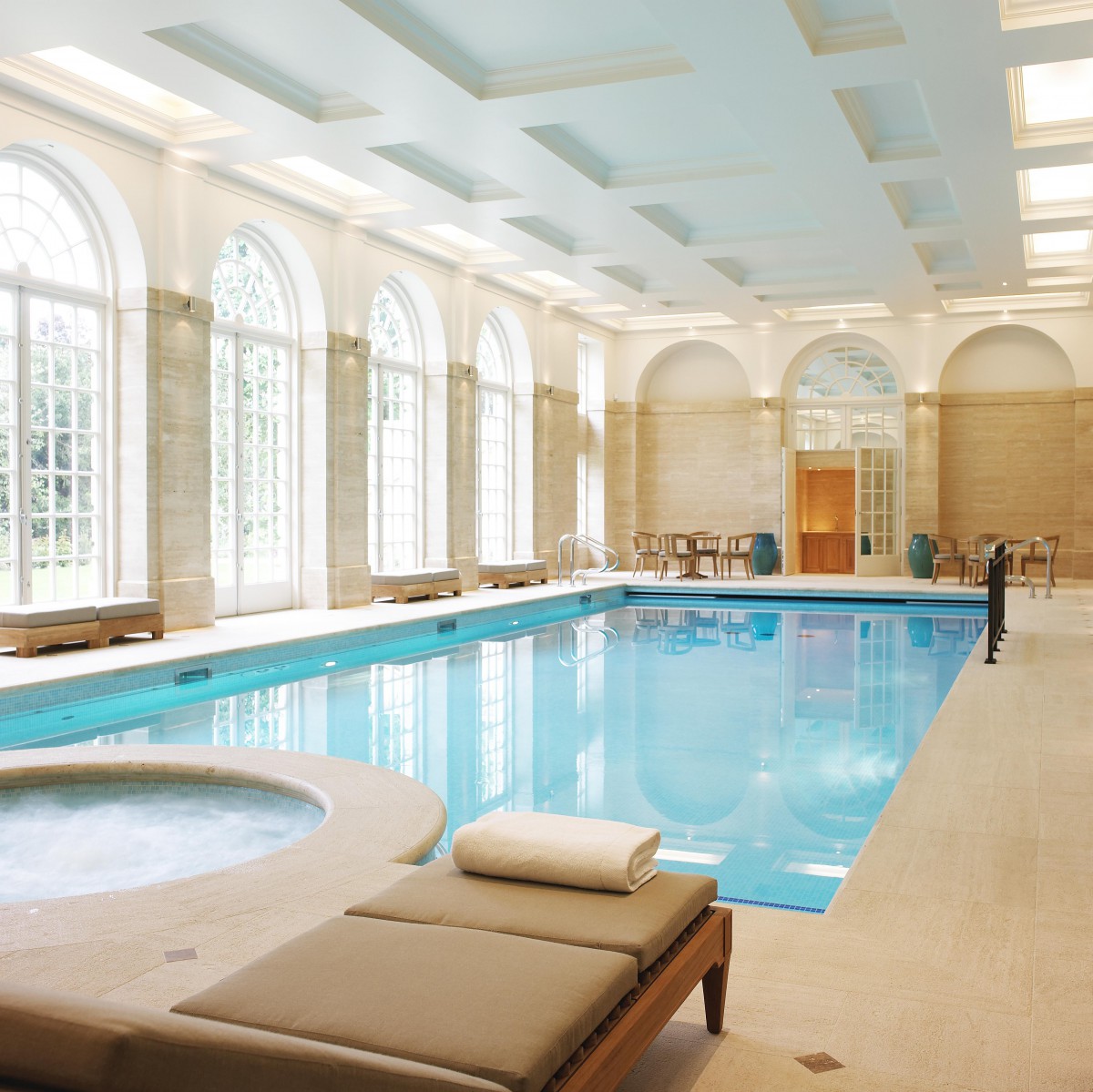 A luxurious indoor swimming pool with elegant architecture and relaxation areas.