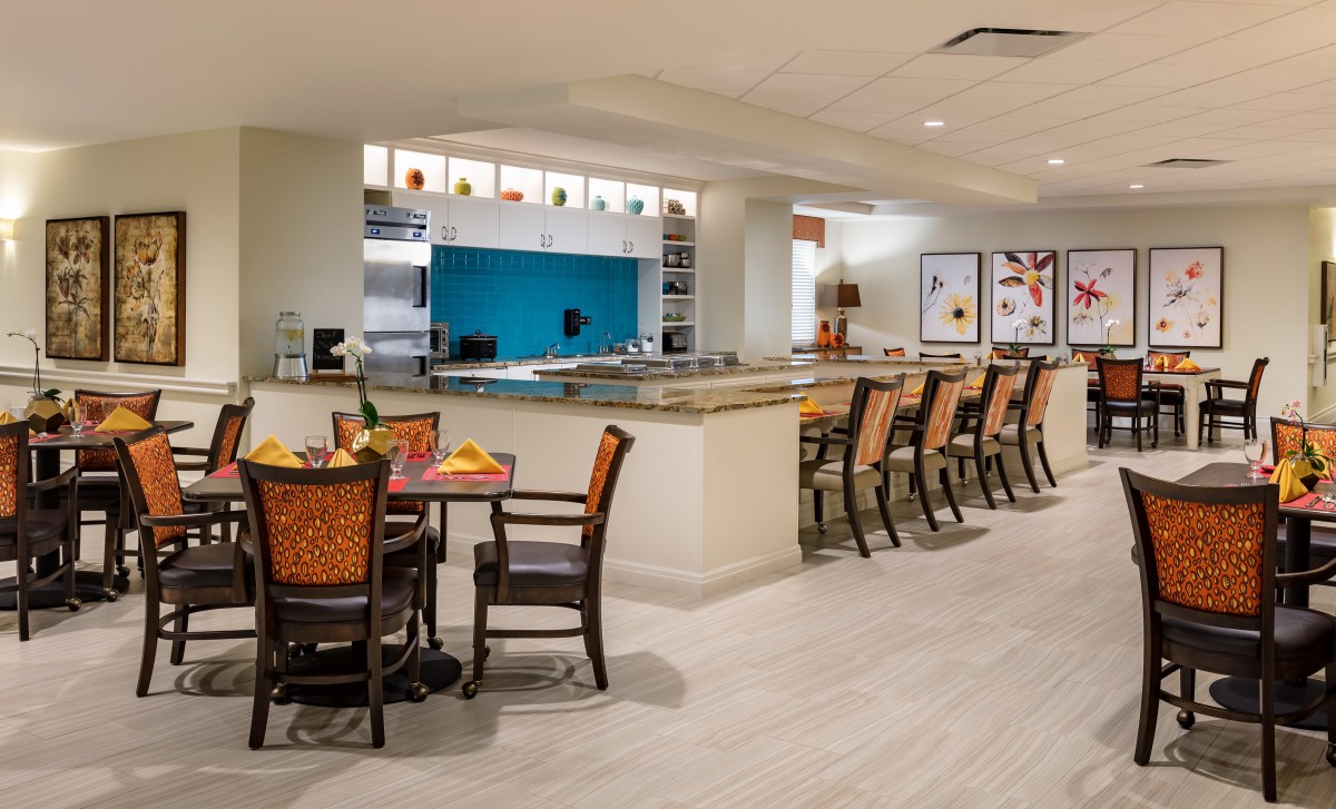 A modern bar and dining area with wooden chairs and a sleek counter.