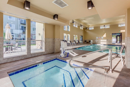 A modern indoor swimming pool area designed for relaxation and fitness, featuring large windows for natural light.