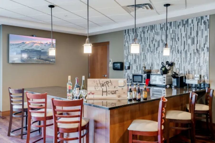 Modern bar interior with hanging lights and a selection of bottles on the counter.
