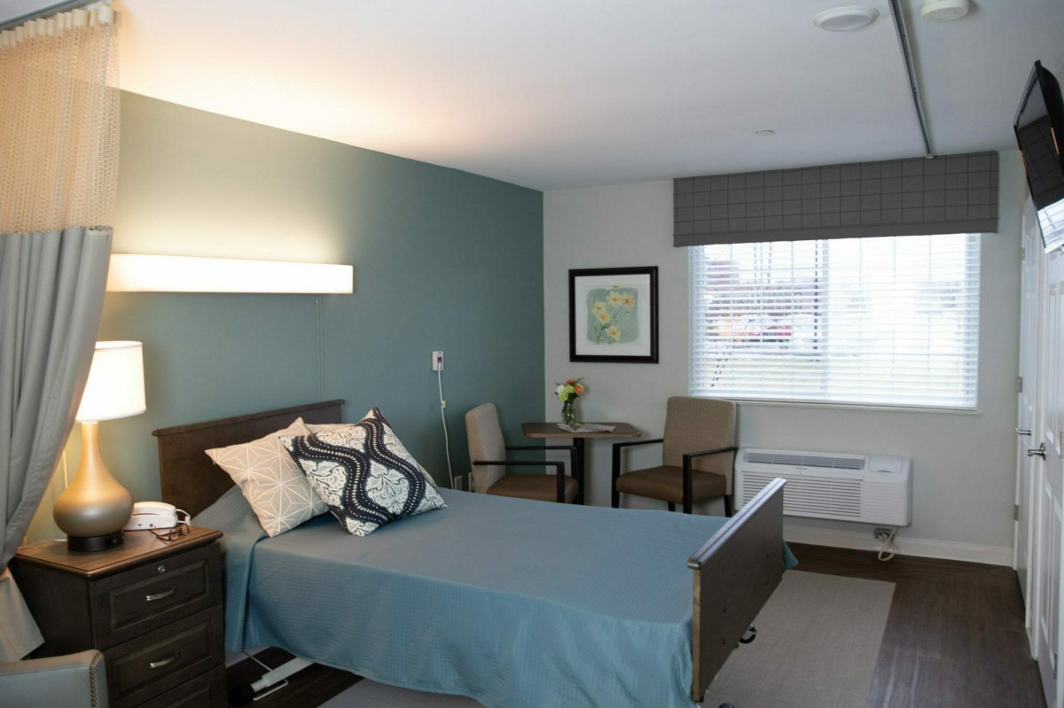 A modern and minimalist bedroom with a single bed and simple decor.