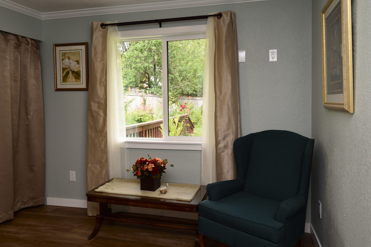A cozy living room with a view of the garden through the window.