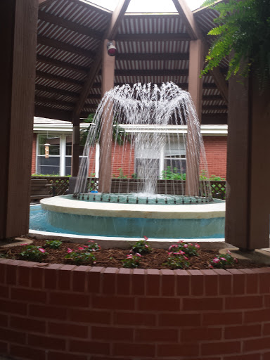 A serene fountain surrounded by lush landscaping, creating a tranquil outdoor space.