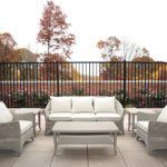 A cozy patio setup with wicker furniture and an autumn backdrop.