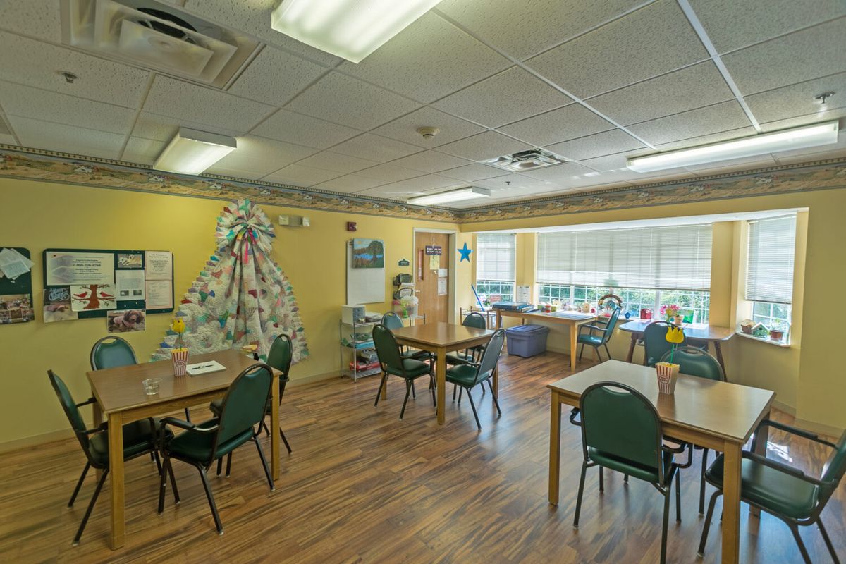 A cozy dining area with tables, chairs, and decorative elements on the walls.