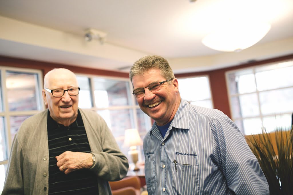 Two men sharing a laugh indoors.