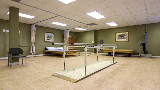 A physical therapy room featuring parallel bars designed for rehabilitation exercises.
