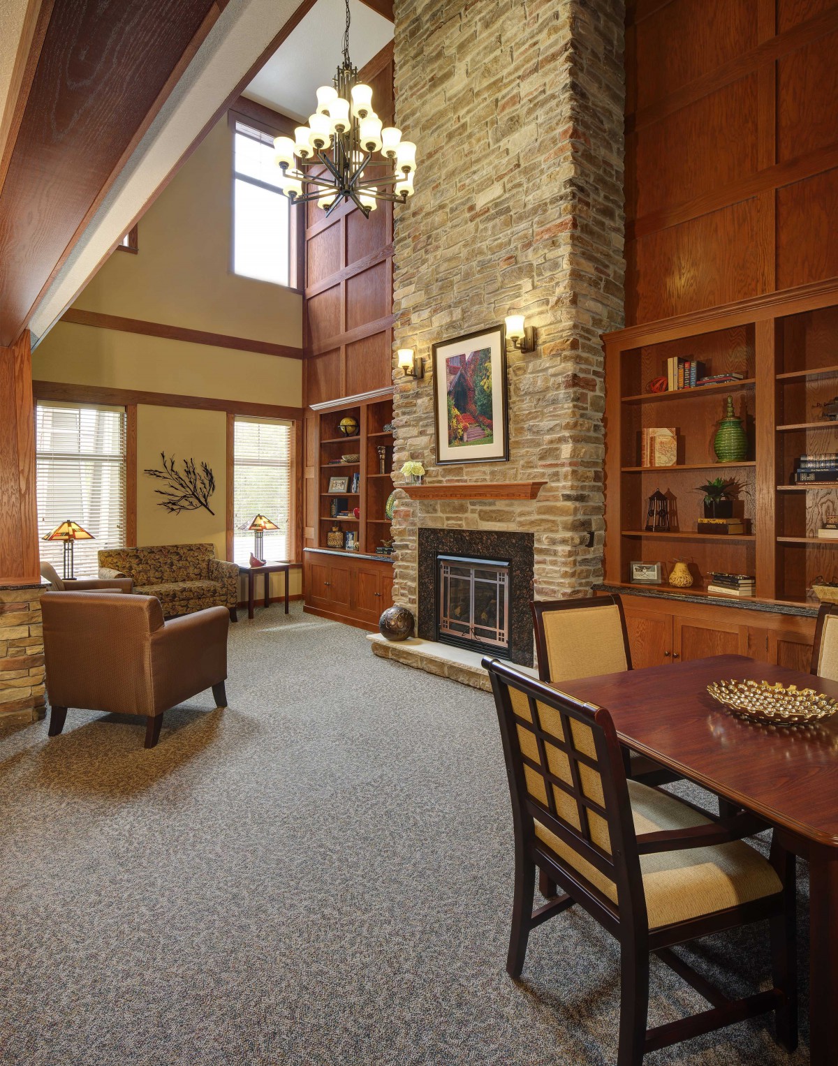 A cozy living room with a fireplace, wooden bookshelves, and comfortable seating.