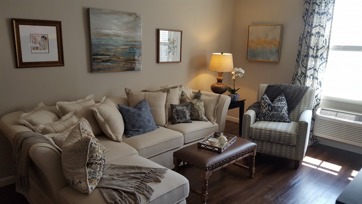 A cozy living room with a sofa, armchair, and decorative wall art.