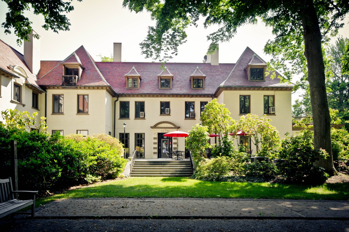 A charming residential house surrounded by lush greenery and trees.