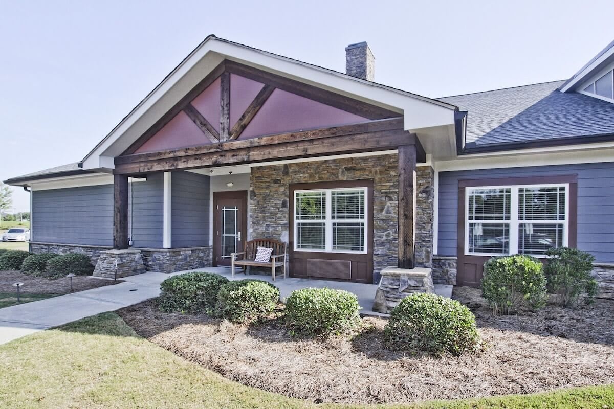 A modern house with a stone facade and neatly landscaped front yard.