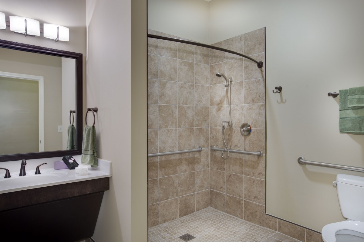 A modern bathroom featuring a tiled walk-in shower and a sink vanity.