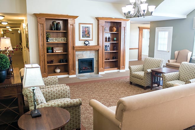 A cozy living room with a fireplace, bookshelves, and comfortable seating.