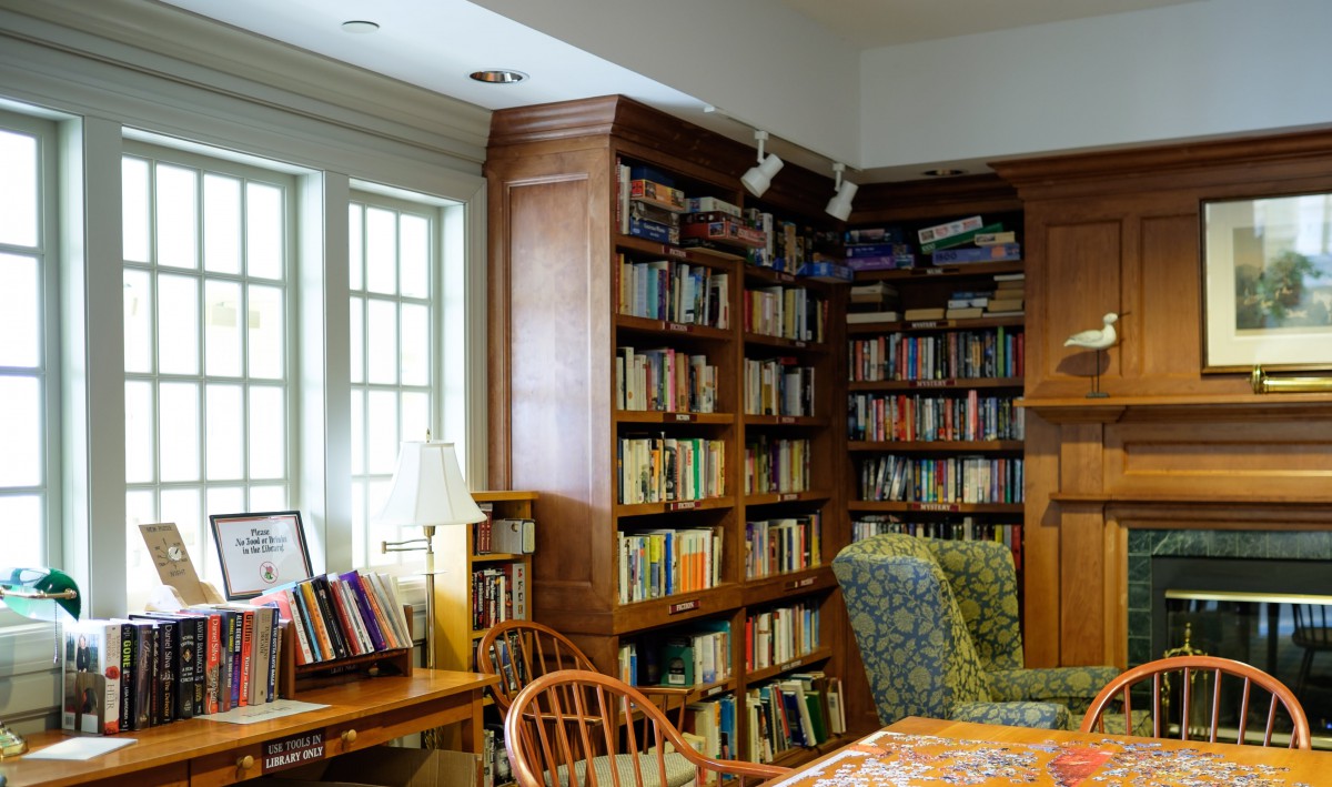 A cozy library corner with wooden bookshelves and comfortable seating.