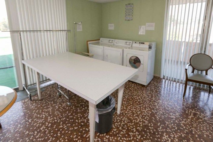 A clean laundry room featuring washing machines and a large folding table.