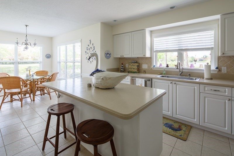A bright and modern kitchen with an island and stools.