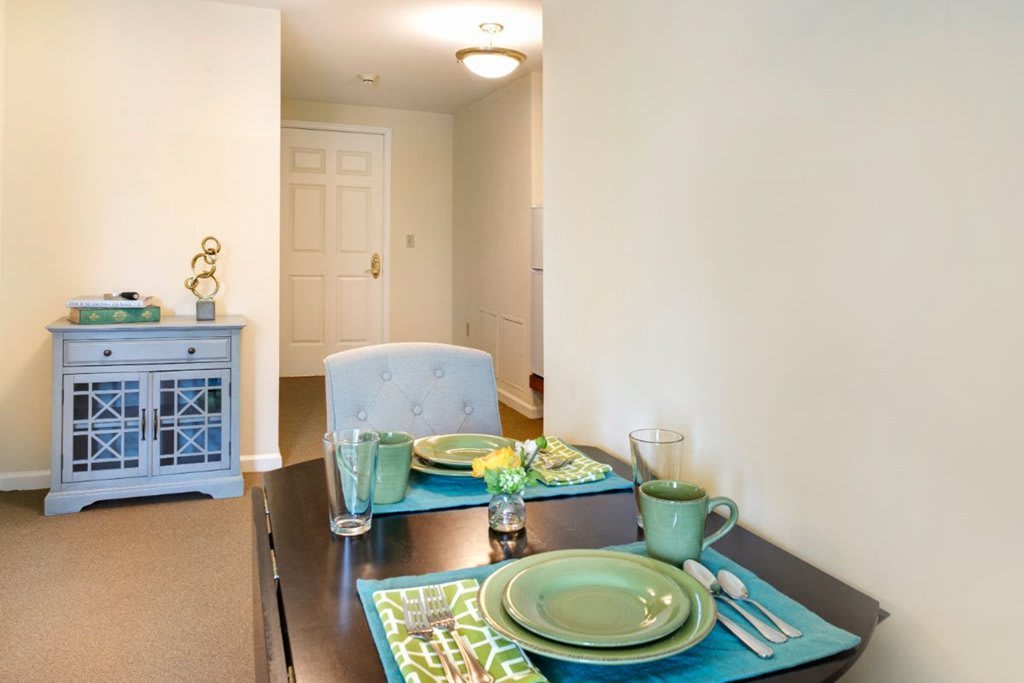 A modern dining area with a green color scheme and elegant table setting.