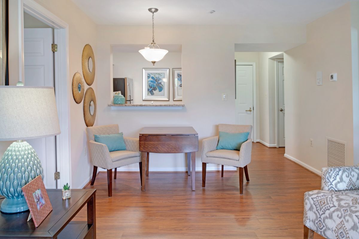 A cozy living area featuring two chairs and a small table, with elegant decor and wooden flooring.