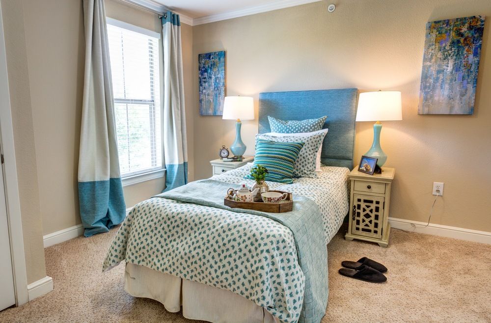 A cozy bedroom with a single bed, decorative pillows, and matching curtains.