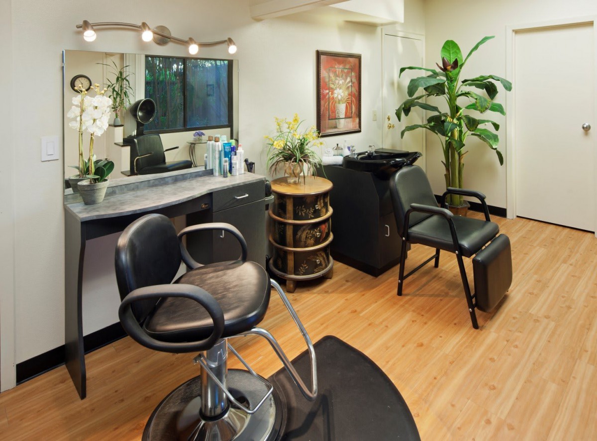 A cozy and well-equipped hair salon interior with stylish seating and decor.