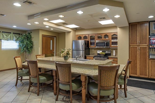 A modern kitchen with a dining area featuring a large table, chairs, and stainless steel appliances.