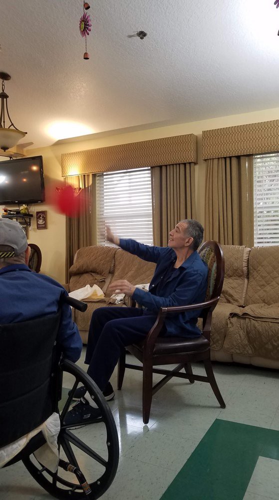 Residents in a care home engaging in a ball game as part of their indoor activities.