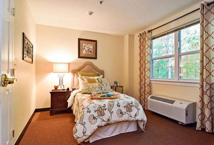 A cozy bedroom with a neatly made bed, soft lighting, and warm decor.