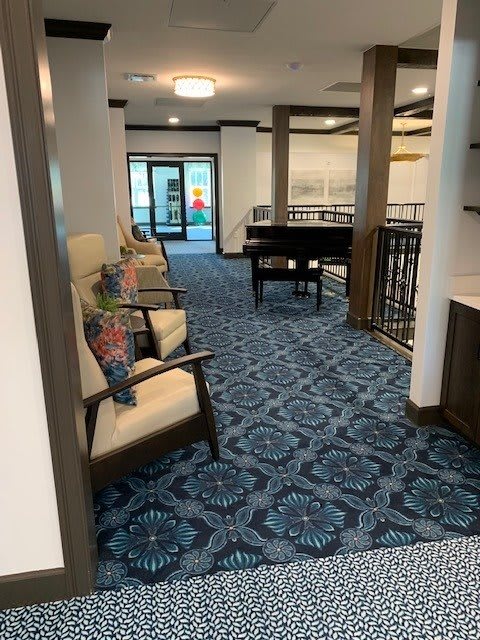 A modern hallway interior featuring comfortable seating and a piano.