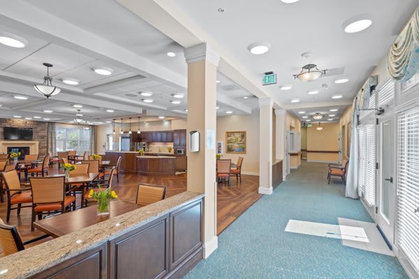 A spacious and well-lit interior of a reception area with lounge seating and a corridor leading to other rooms.