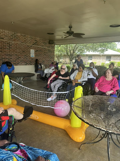 Seniors enjoying a social gathering outdoors, engaged in activities with friends.