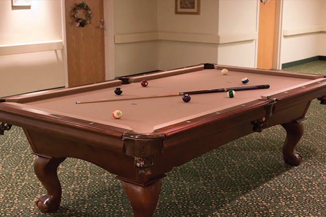 A pool table set up for a game in a cozy indoor setting.