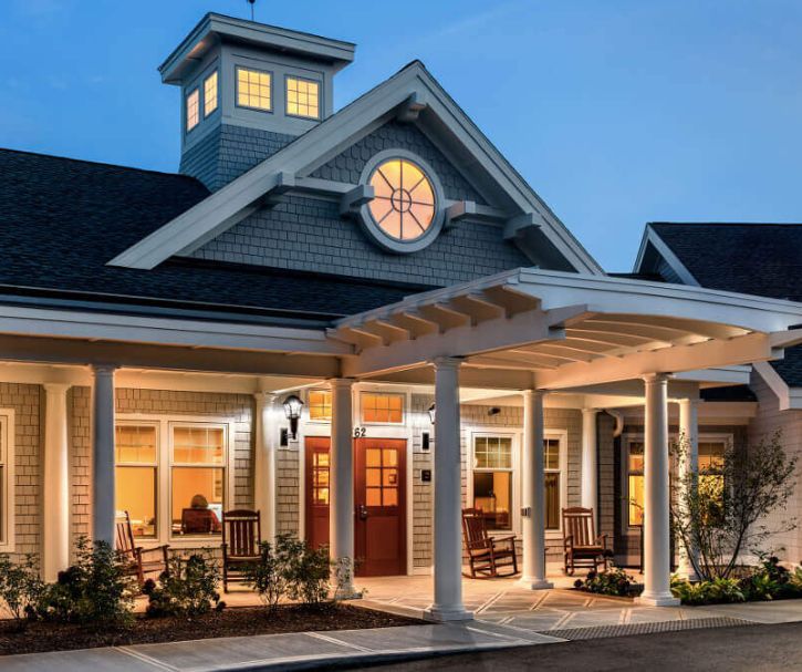 A beautifully lit house with a welcoming porch during the evening.