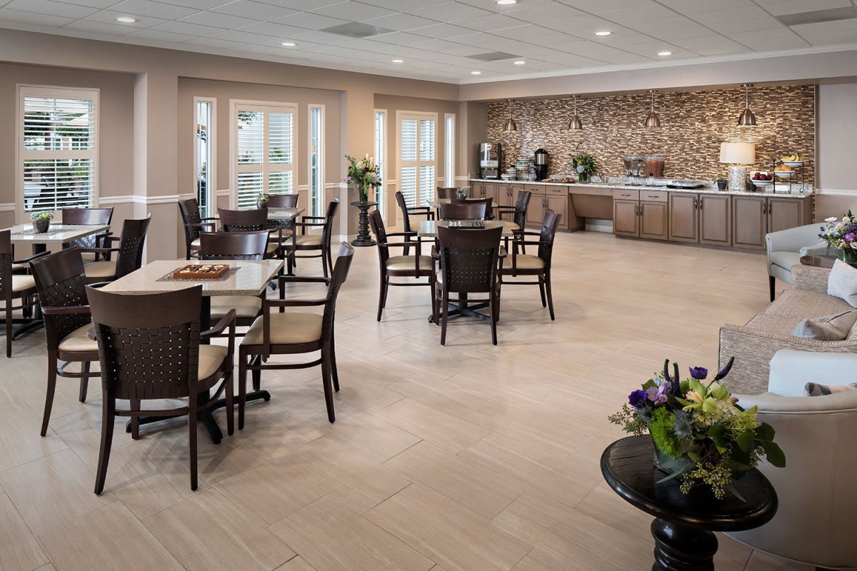 A spacious dining room with neatly arranged tables and a buffet area.