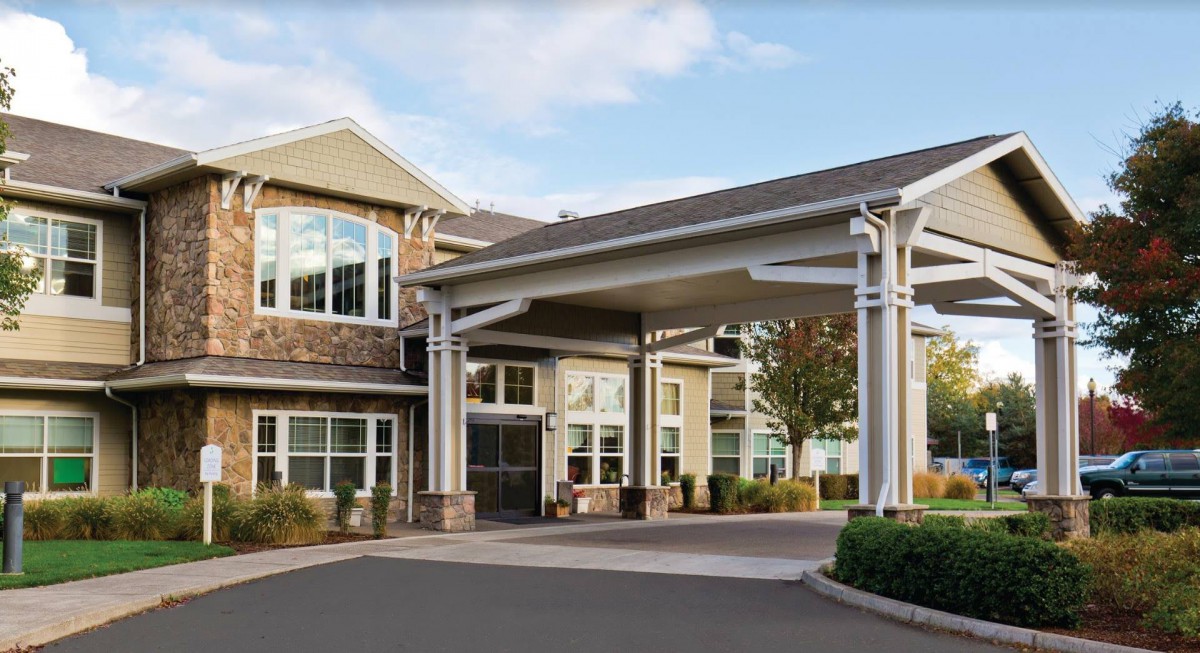 A modern building with a covered entrance and driveway.