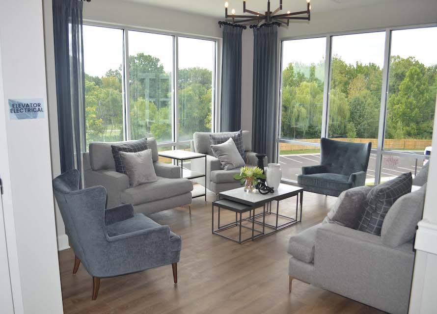 A modern living room with large windows, stylish furniture, and abundant natural light.