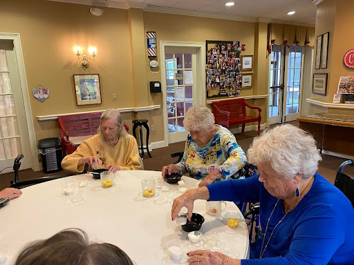 A group of elderly women enjoying a creative activity together in a community setting.