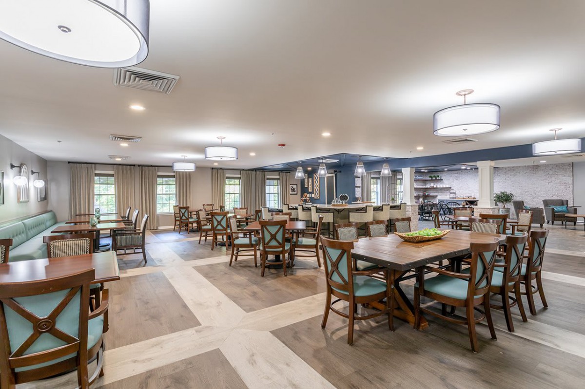 Spacious dining area with multiple tables and chairs, well-lit with modern lighting.