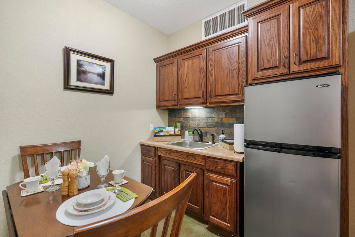 A cozy kitchen with wooden cabinetry and a small dining area.