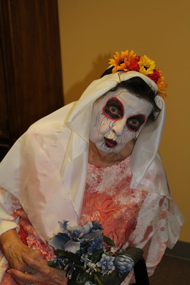 A person dressed in spooky Halloween makeup with a flower crown.