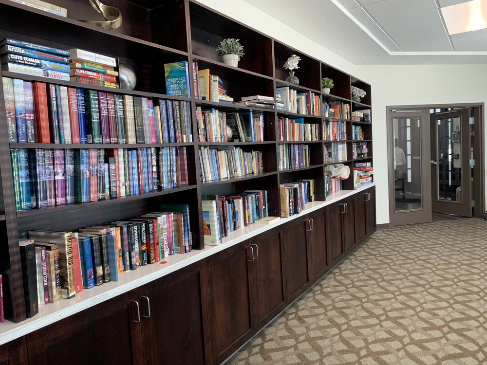 A spacious library room featuring large wooden bookshelves filled with a variety of books.