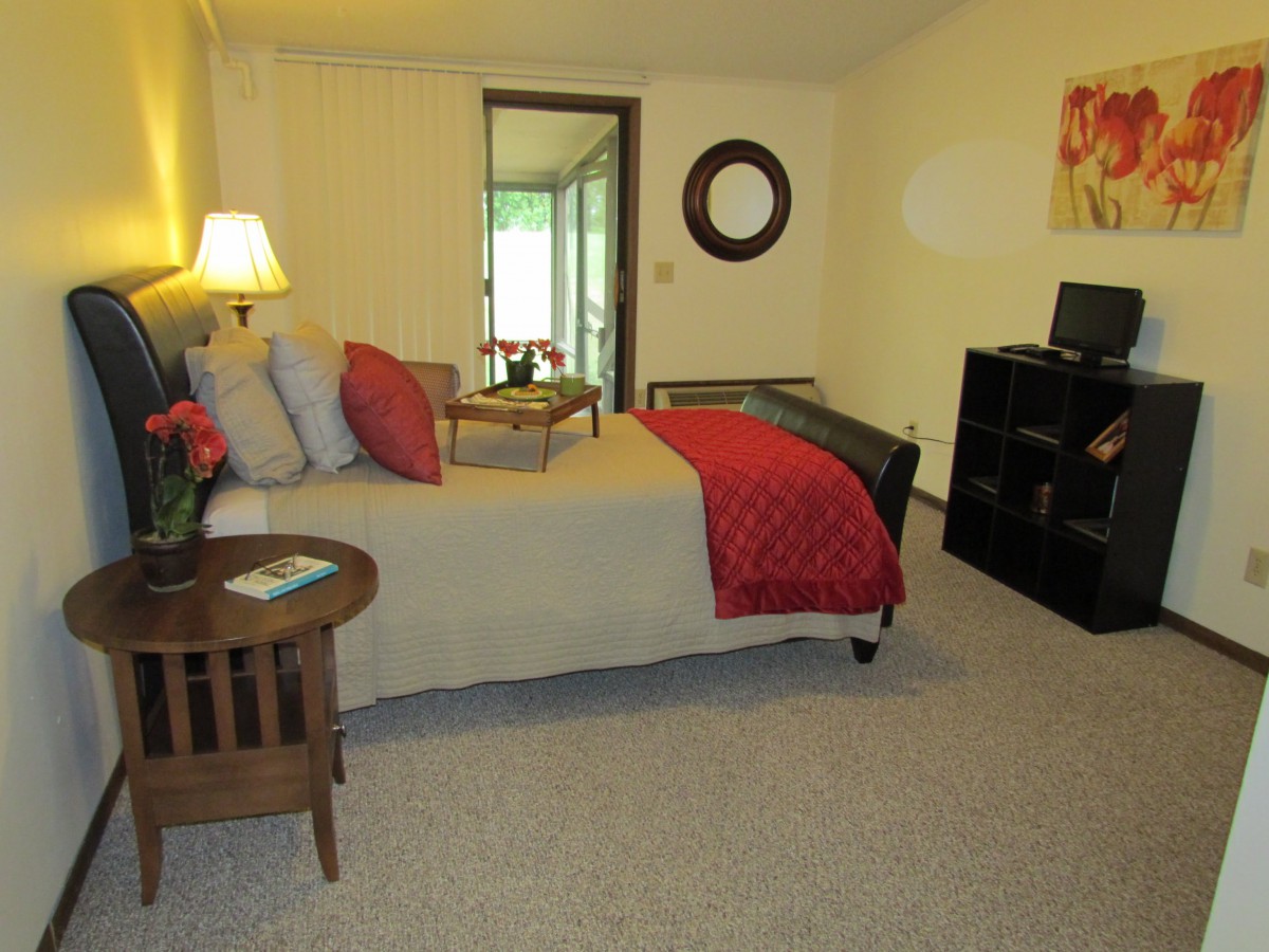 A cozy bedroom with a neatly made bed, a lamp on the side table, and decorative elements enhancing the ambiance.