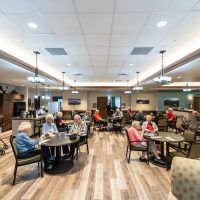 A group of seniors socializing in a community seating area indoors.