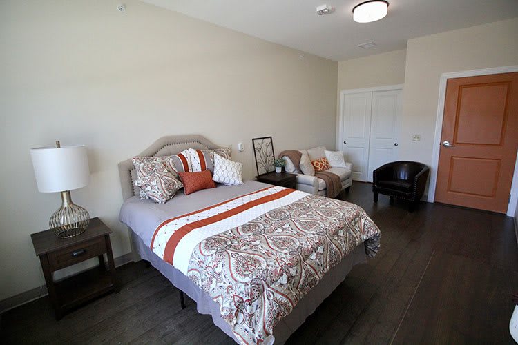 A well-decorated bedroom with a cozy bed, stylish cushions, and comfortable seating.