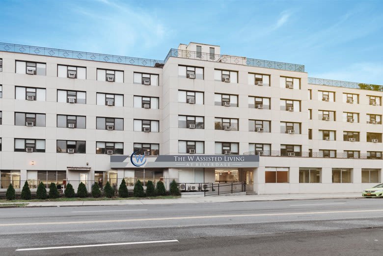A modern hotel building with multiple windows and a clear blue sky.
