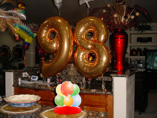 A festive setup featuring golden balloons displaying the number '98' for a birthday celebration.