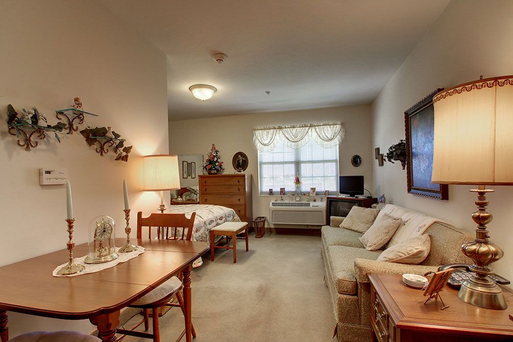 A cozy studio apartment with a combined living and bedroom area, featuring a small dining table and a comfortable sofa.