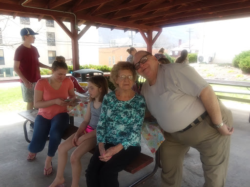 A joyful family gathering under a gazebo, enjoying each other's company.