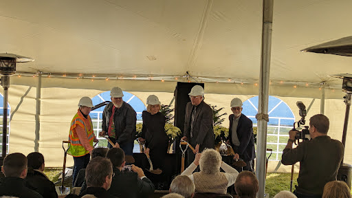 Participants gather for a groundbreaking ceremony, preparing to mark the start of a new construction project.
