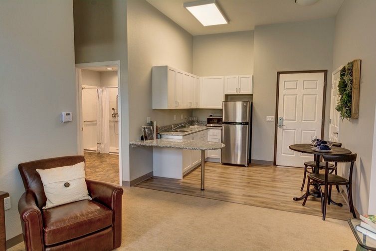 A modern open-space apartment interior featuring a kitchen and living area.