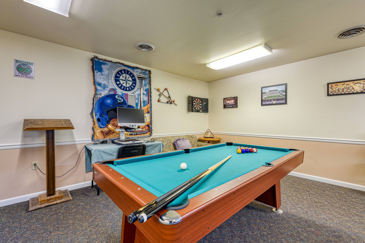 A cozy game room featuring a pool table, sports memorabilia, and recreational decor.
